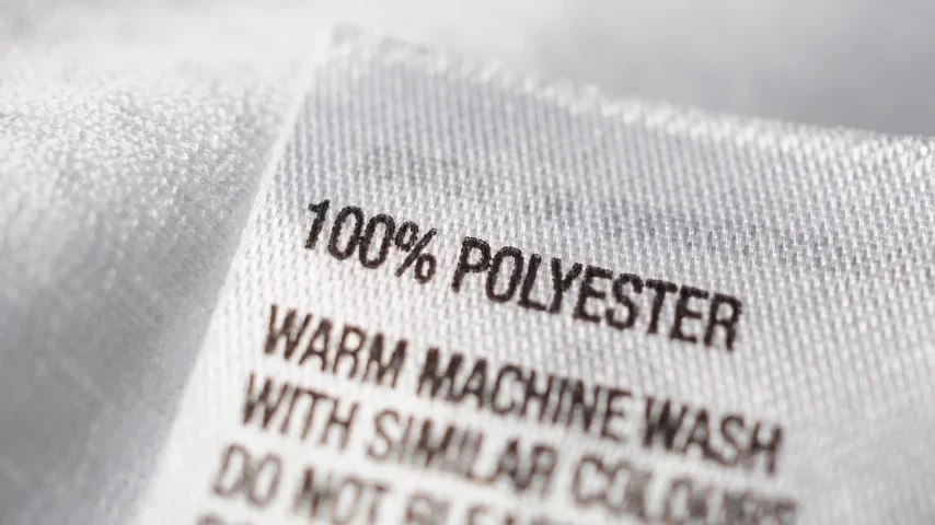 A polyester garment label with washing instructions.