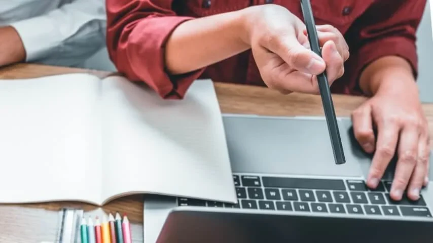 A designer working with a laptop and color references.