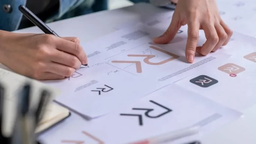 Comparing printed logo shapes during an artwork review.